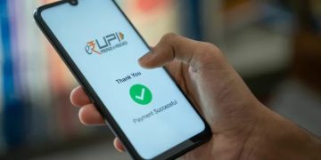 Person making a UPI payment on a smartphone while reviewing a transaction after accidentally sending extra money.